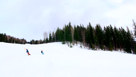 People-snowboarding-on-snowy-mountain