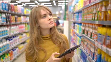 Mujer-cliente-utilizando-una-tableta-digital-en-el-supermercado