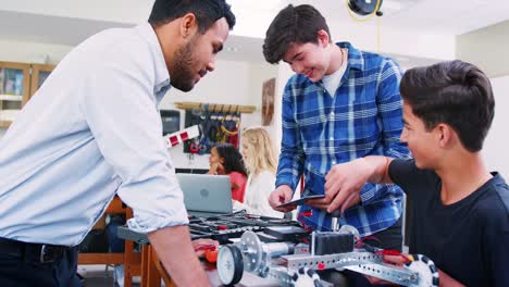 Gymnasiallehrer-mit-männlichen-Schüler-Gebäude-Roboterfahrzeug-In-Wissenschaft-Lektion