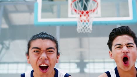 Porträt-von-wettbewerbsfähigen-männlich-High-School-Basketballteam-mit-Trainer-auf-Platz