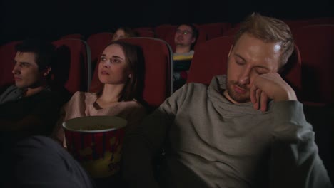 Sueño-de-hombre-en-la-película-de-cine.-Chico-durmiendo-en-la-fecha-de-cine.-Gente-ver-película-aburrida