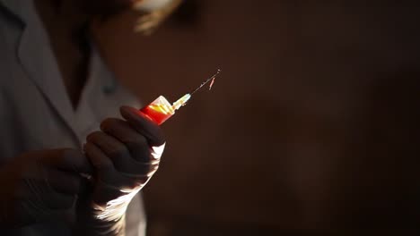 Monstrous-doctor-stained-blood-and-with-bandage-on-one-eye,-holds-syringe-with-blood