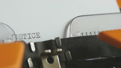 Close-up-footage-of-a-person-writing-JUSTICE-on-an-old-typewriter,-with-sound