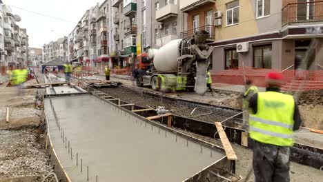 Betonarbeiten-für-den-Straßenbau-Wartung-mit-vielen-Arbeitern-und-Mixer-timelapse