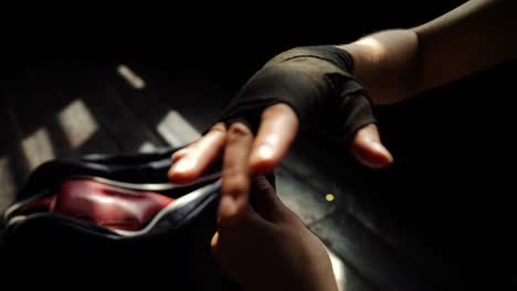 Closeup-fit-woman-wrapping-hands-with-bandage-tape-preparing-for-boxing-training-slow-motion