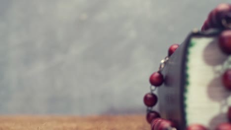 Open-Bible-and-the-crucifix-beads-on-a-golden-table,-close-up.-Beautiful-dark-background.-Religion-concept