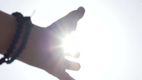 Search-of-God-concept,-hands-reaching-up-to-sun-asking-help,-divine-bright-light