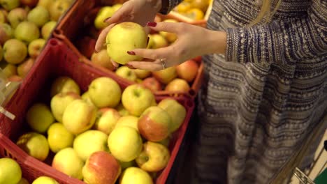 Hände-von-Frau-Wahl-Apfel-Obst-Gemüse-Supermarkt