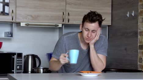 Isst-der-Mensch,-beim-Einschlafen,-Haferflocken-und-Kaffee-in-der-Küche