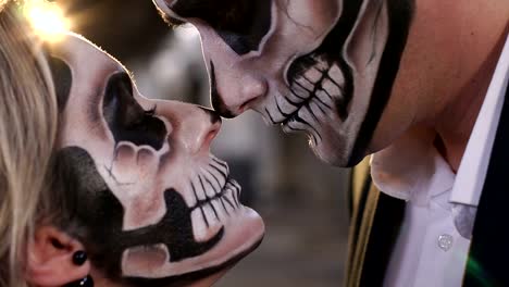 Halloween-loving-couple-with-skull-makeup-looking-at-each-other.