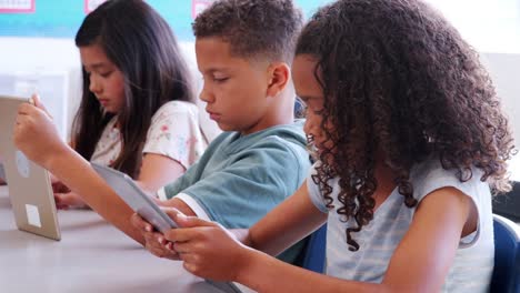 Drei-Schüler-mit-Tabletten-in-einer-Lektion-in-der-Grundschule