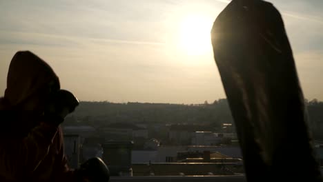 Boxer-with-fighting-gloves-stands-in-guard-punches-bag-in-sunset,-close-up,-city,-sportsman-practicing,-power-training,-strong-guy-hard-exercising,-strength-exercises,-workout,-handheld,-sunny-day.