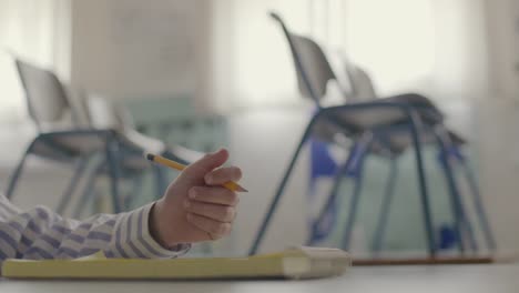 Estudiante-masculino-mano-escribe-cuaderno-en-blanco-educación-concepto