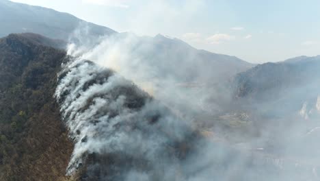 Aerial-footage-of-thick-smoke-coming-from-the-woods,-the-shot-is-moving-forward...