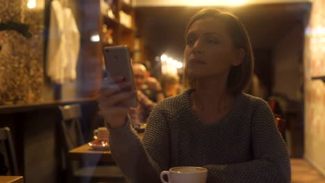 Young-woman-chatting-on-smartphone,-sitting-in-cozy-coffee-house,-free-wi-fi