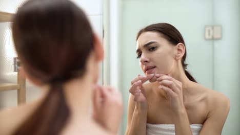 Problem-Skin.-Woman-Crushing-Spot-On-Face-And-Looking-In-Mirror