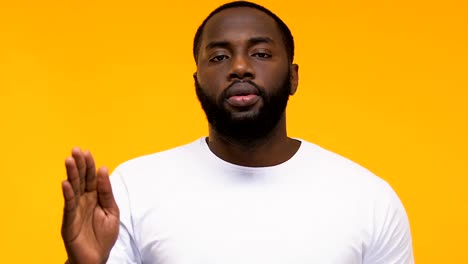 Confident-Afro-American-man-showing-stop-sign-male-against-racial-discrimination