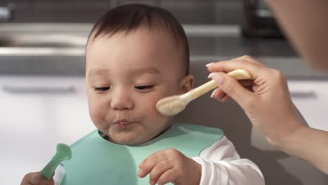 Sloppy-1-Year-Old-Asian-Baby-Being-Fed-Puree