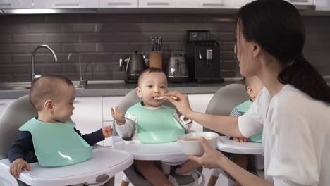 Filipino-Nanny-Feeding-1-Year-Old-Triplets-in-High-Chairs