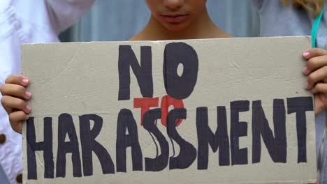 Upset-girl-holding-banner-with-No-harassment-slogan,-against-domestic-violence