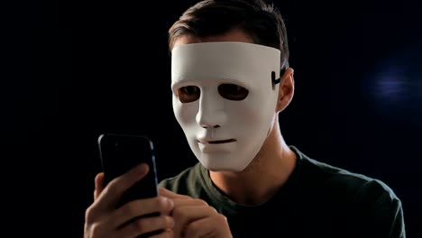 Anonymous-masked-fraudster-demands-a-ransom-for-blackmail-using-a-smartphone.-Masked-Criminal-intimidates-the-victim-with-the-help-of-threats-via-SMS-using-mobile-phone.