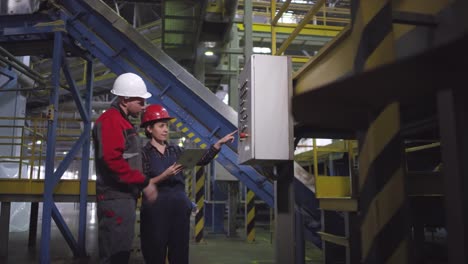 Female-Engineer-Operating-Control-Console-and-Talking-to-Colleague