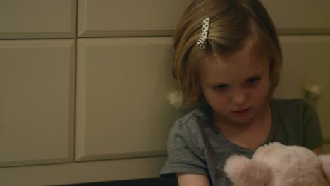 Sad-and-angry-young-girl-sits-on-her-bedroom-floor-alone-holding-a-stuffed-animal