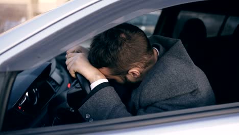 Joven-barbudo-a-hombre-de-negocios-sentado-en-coche-muy-alterado-y-subrayó-después-fracaso-duro-y-móvil-atasco-de-tráfico