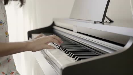 4K-:-Slow-motion-of-Asian-girl-playing-piano,-Pan-shot