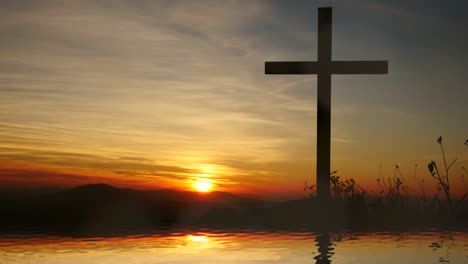 Cruz-de-Jesucristo,-cerca-del-agua-con-la-puesta-de-sol-y-estado-de-ánimo-tranquilo.