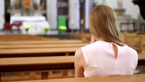 Young-gewidmet-religiöse-Frau-in-der-katholischen-Kirche-zu-beten.-Gläubigen-katholischen-europäischen-Kathedrale