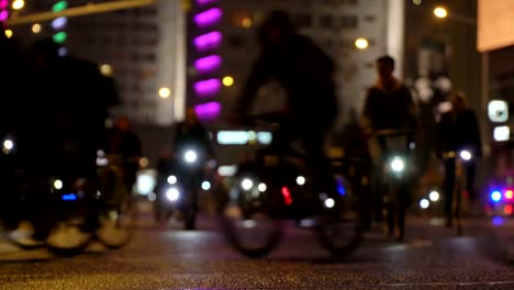 Viele-Radfahrer-fahren-während-der-Nacht-Radfahren-Fahrrad,-Fahrrad-Parade-in-Unschärfe-durch-die-beleuchtete-Nacht-Stadt-Straße-Zeitraffer.-Menschenmenge-am-Fahrrad.-Radverkehr.-Konzept-Sport-gesunde-Lebensweise.-Hell-leuchtende-Lichter.-Niedrigen-Winkel-Ansicht