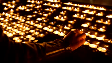 Woman-lighting-round-candles-at-the-church,-religion-and-faith,-spirituality