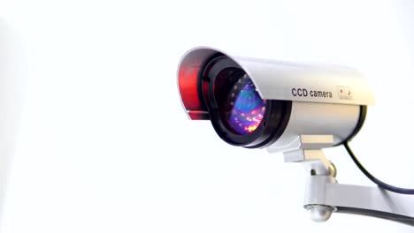 The-surveillance-camera-with-flashing-red-light-on-white-background.-Close-up