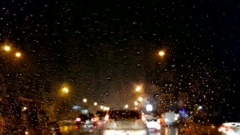 Traffic-jam-in-the-rain,-driver-pov,-cars-driving-slowly,-evening-in-city