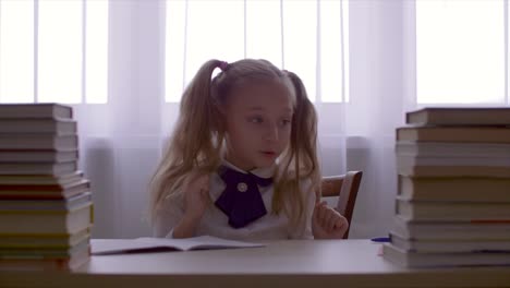 Portrait-school-girl-girl-having-fun-and-dancing-at-table-with-textbooks-stack