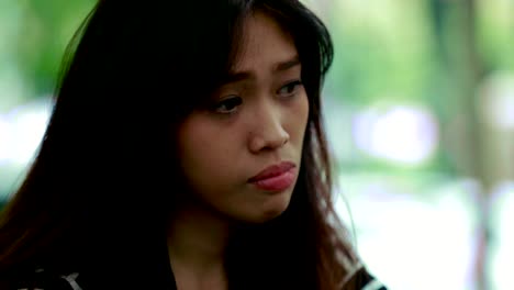 Close-up-on-beautiful-asian-young-woman-crying-alone-in-outdoors-with-three-kind-of-tones