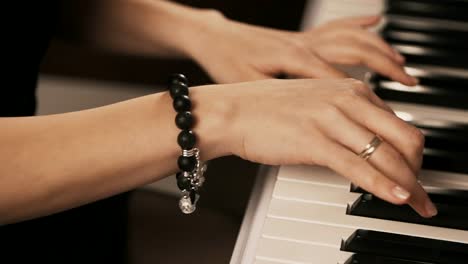 Female-hands-playing-piano.-Woman-touches-fingers-on-keys.-Close-up