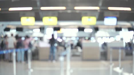 Unscharfe-Aufnahmen-der-Passagiere-zu-Fuß-zum-Check-in-Schalter-am-Flughafen-terminal.-4K-Video-mit-defokussierten-Wirkung.