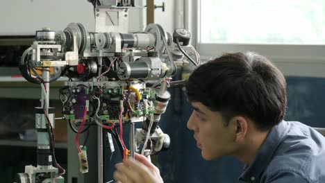 Asiatische-junge-Elektronik-Ingenieur-Bau-&-Befestigung-Robotik-im-Labor.-Menschen-mit-Technologie-oder-Innovation-Konzept.