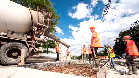 Obras-de-hormigón-para-construcción-de-mantenimiento-de-carreteras-con-muchos-trabajadores-y-mezclador-timelapse-hyperlapse