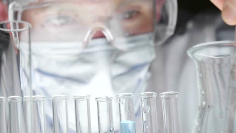In-a-laboratory,-a-scientist-with-a-pipette-analyzes-a-colored-liquid-to-extract-the-DNA-and-molecules-in-the-test-tubes.