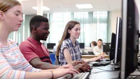 Gruppe-von-Schülerinnen-und-Schüler-gemeinsam-In-Computer-Klasse