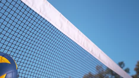 SLOW-MOTION:-Ball-gets-caught-in-a-black-and-white-net-during-volleyball-game.