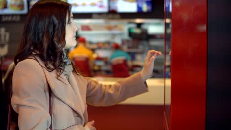 Beautiful-woman-in-a-coat-food-orders-through-the-terminal