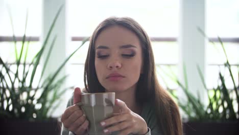 Müde-Frau-trinkt-Kaffee-trinken-im-Innenbereich