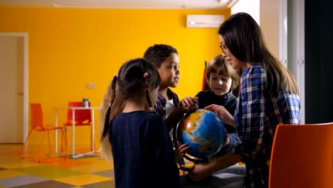 Diverse-Kinder-und-Lehrer-mit-Globus-im-kindergarten