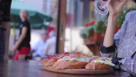 Essen-und-trinken.-Closeup-Frau-trinkt-Wein-mit-Snacks