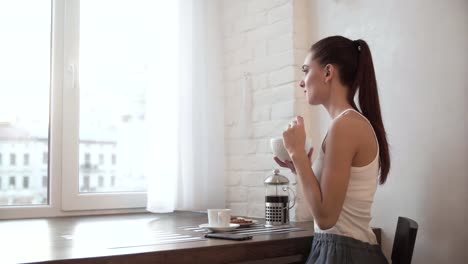 Mujer-desayunando-en-casa,-disfrutando-de-comida-de-mañana