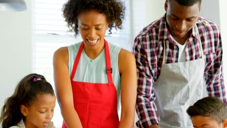 Front-view-of-black-family-using-cookie-cutter-in-kitchen-at-home-4k